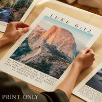 A person's hands holding a printed poster with a mountain landscape and text overlay.