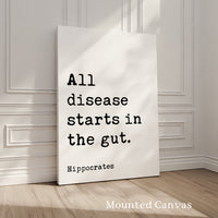 A white canvas with black text that reads "All disease starts in the gut. Hippocrates" against a white wall background.