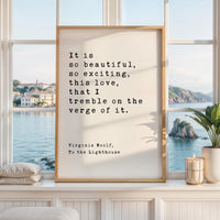 May include: A framed print with the quote "It is so beautiful, so exciting, this love, that I tremble on the verge of it." by Virginia Woolf. The print is in a light wood frame, displayed on a white surface with a window view.