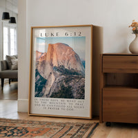 A framed photograph of a mountain landscape is displayed on a wall in a living room.