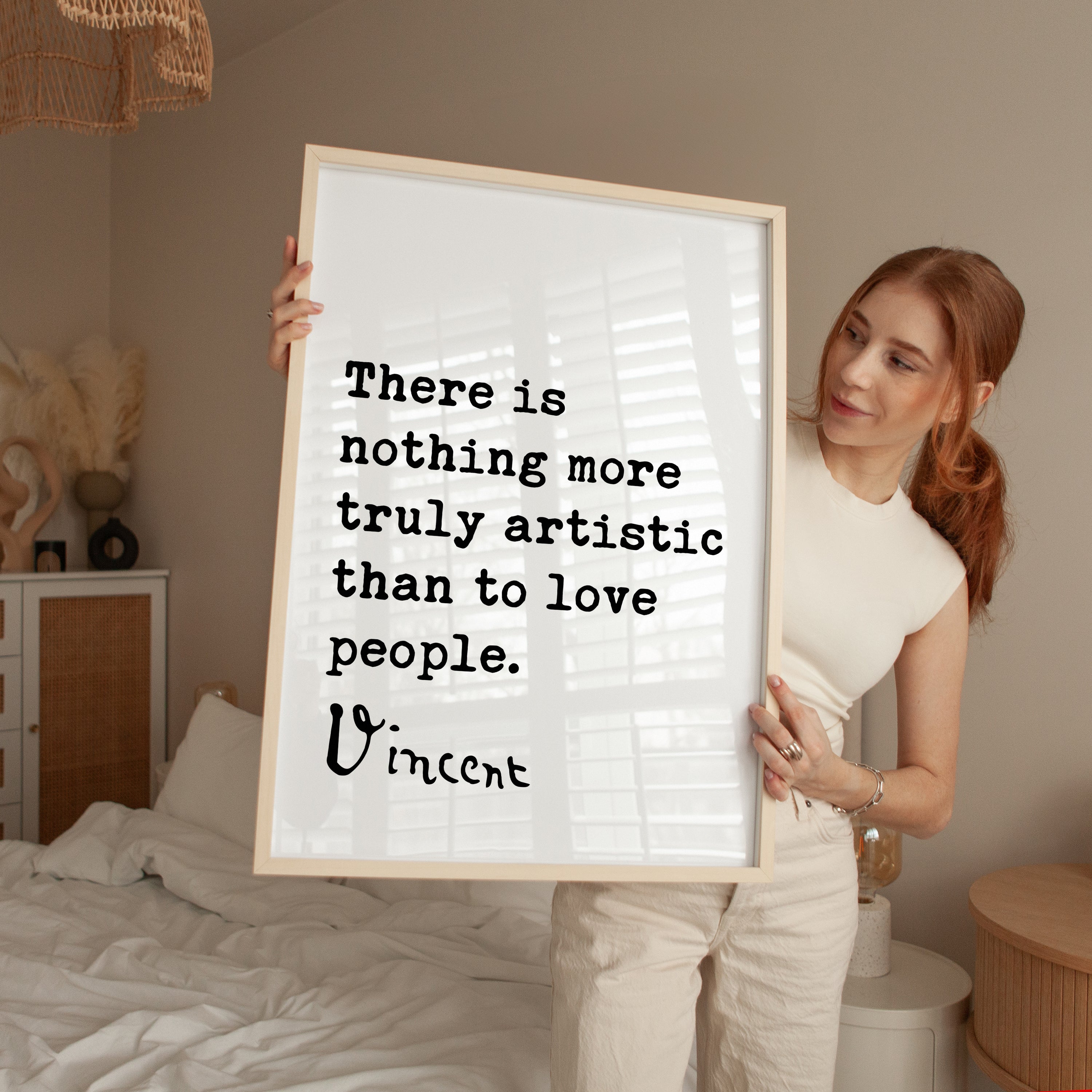 A woman holding a framed quote in a bedroom.