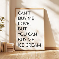 May include: A rectangular wall art print in a light wood frame featuring the black text CAN'T BUY ME LOVE BUT YOU CAN BUY ME ICE CREAM on a white background. The print is displayed in a vertical orientation with clean, sans-serif typography.
