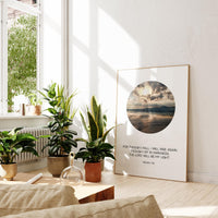 a living room with plants and a picture on the wall