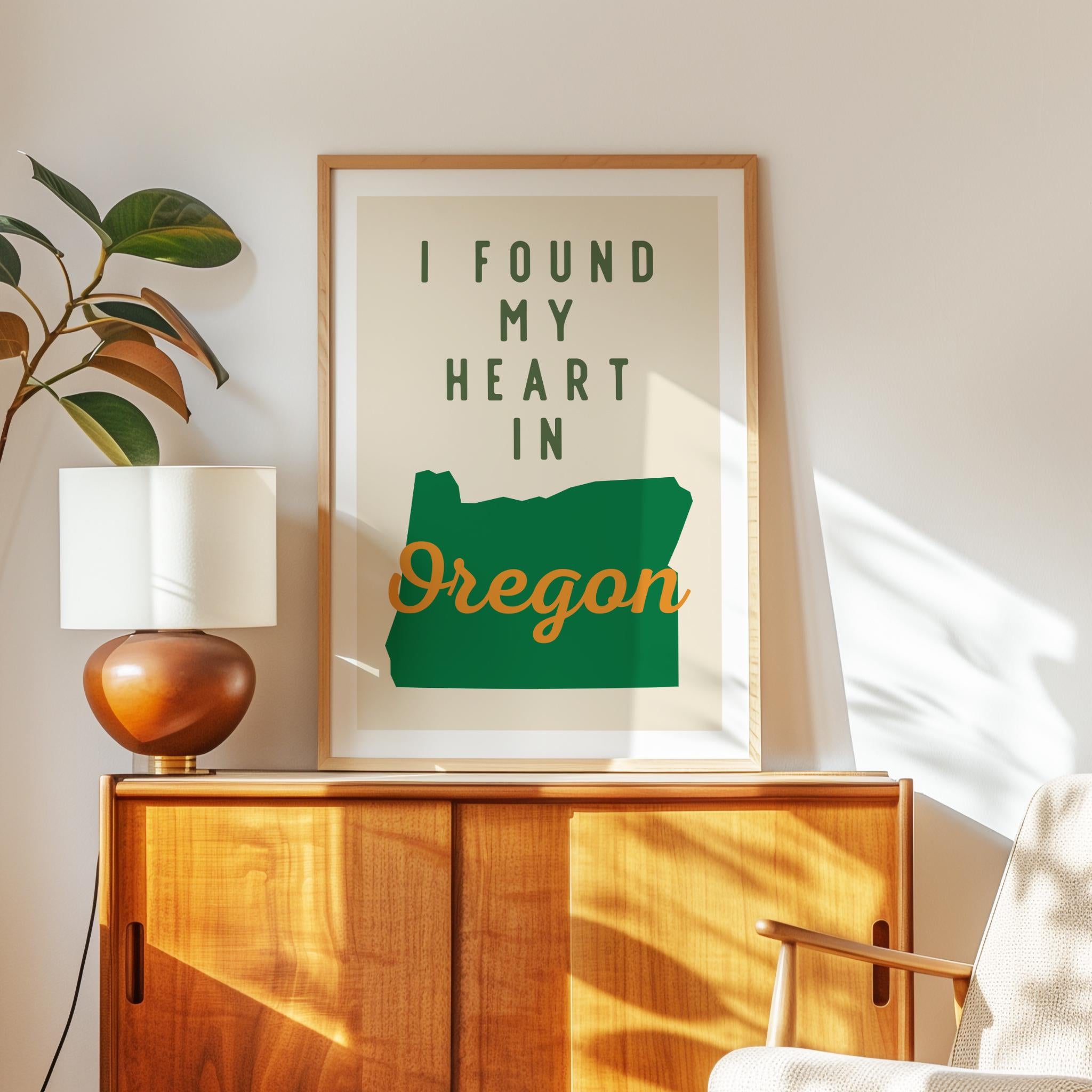 a framed poster with the text "I FOUND MY HEART IN OREGON" displayed on a wooden cabinet.
