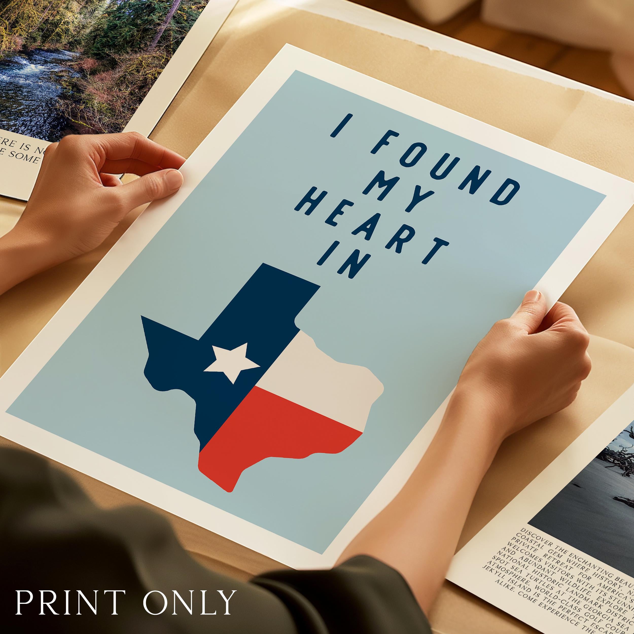 A person's hands are holding a framed print with a Texas state map and the text "I FOUND MY HEART IN" printed on it.