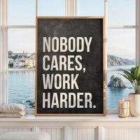 May include: A rectangular framed wall art piece featuring a dark charcoal gray background with a textured, chalkboard-like appearance. The text NOBODY CARES, WORK HARDER. is printed in large, bold, white sans-serif capital letters.