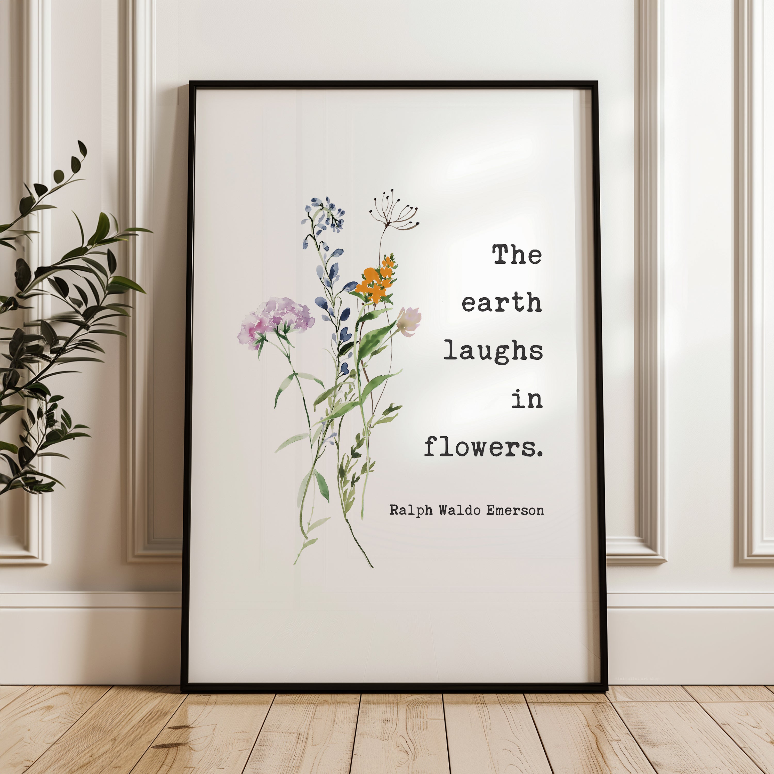 a framed quote by Ralph Waldo Emerson about the earth laughing in flowers.