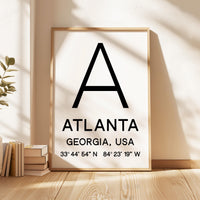 May include: A framed print with a white background and black text. The text reads 'A', 'ATLANTA', 'GEORGIA, USA', and '33° 44' 54' N 84° 23' 19' W'.