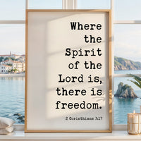 a framed quote from the Bible, specifically 2 Corinthians 3:17, which reads "Where the Spirit of the Lord is, there is freedom." The quote is set against a scenic background of a body of water and a coastal town.