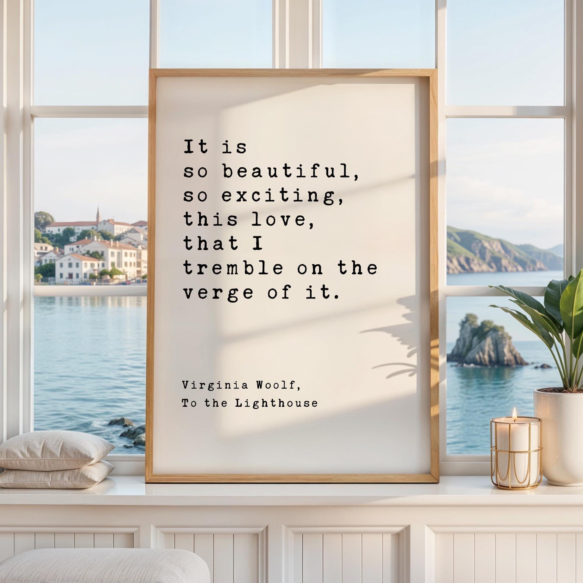 May include: A framed print with the quote "It is so beautiful, so exciting, this love, that I tremble on the verge of it." by Virginia Woolf. The print is in a light wood frame, displayed on a white surface with a window view.