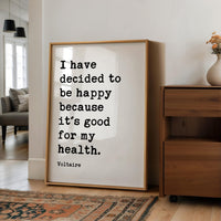 a framed quote by Voltaire that reads "I have decided to be happy because it's good for my health."