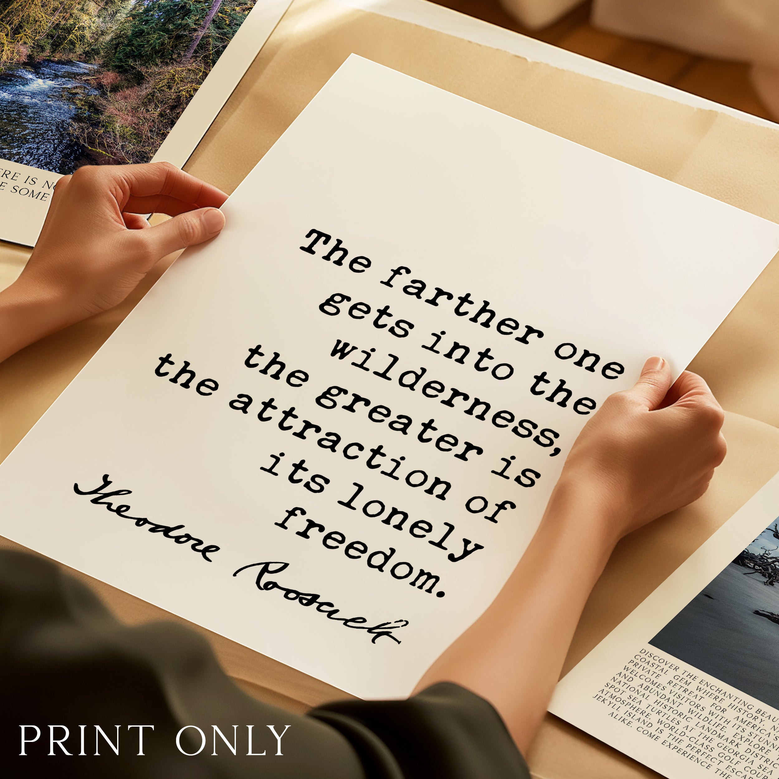 A person's hands holding a printed quote on a piece of paper, with a forest scene visible in the background.