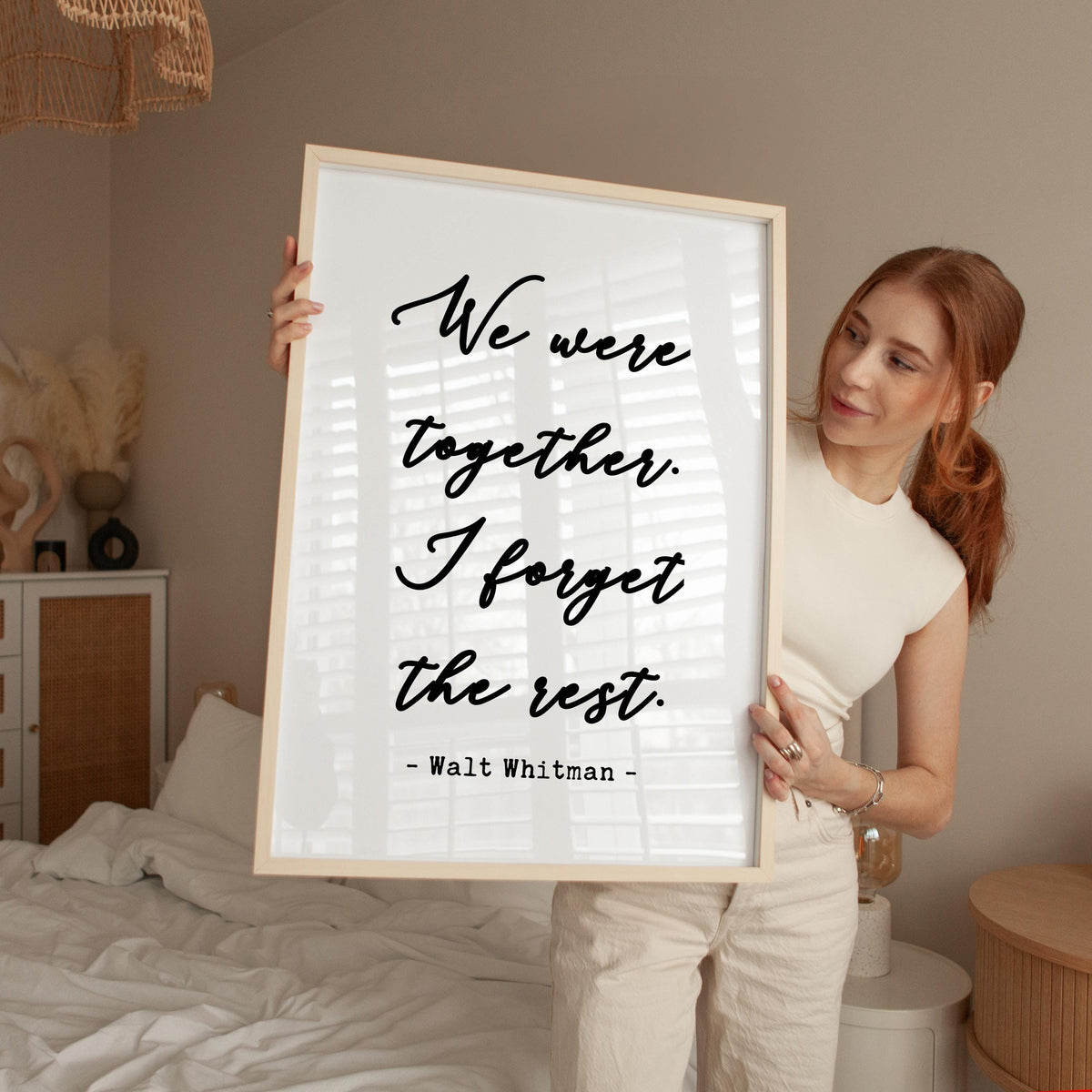 a woman holding a framed poster with a quote