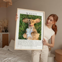A woman holds a framed photograph of a golden retriever dog in a grassy field, with a caption describing the dog as "Wally" and a personal message about the dog's love and loyalty.