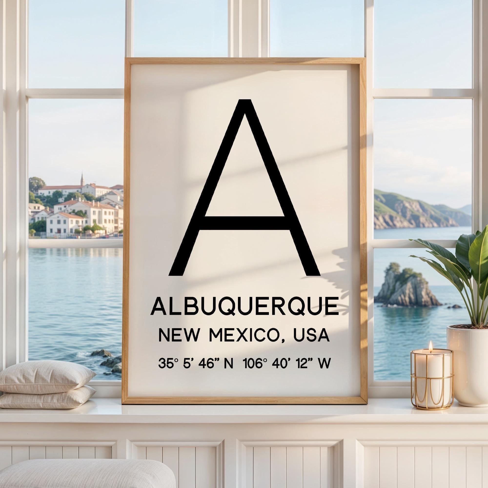 May include: A rectangular wall art print in a light wood frame featuring a large black letter A centered at the top. Below the letter, the text reads ALBUQUERQUE, NEW MEXICO, USA, followed by the coordinates 35° 5' 46" N 106° 40' 12" W.