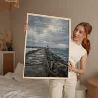 a woman holding up a picture of a lighthouse