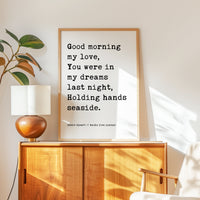 a wooden cabinet with a lamp on top, and a framed quote on the wall next to it.