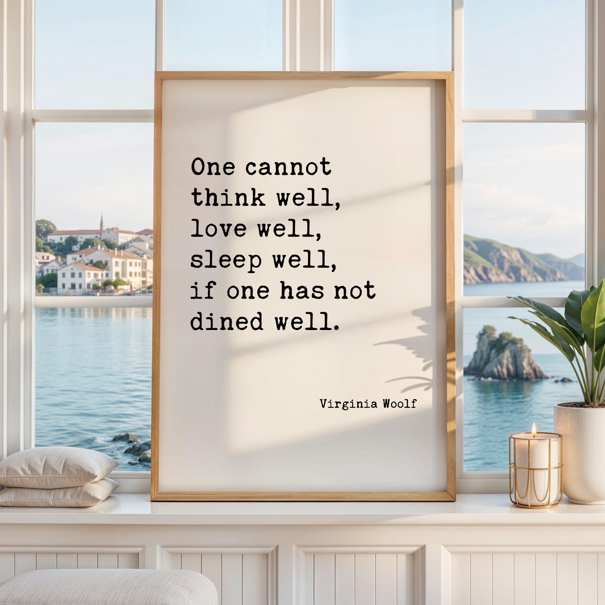 a framed quote by Virginia Woolf, which reads "One cannot think well, love well, sleep well, if one has not eaten well." The quote is displayed in a white frame, and the background shows a scenic view of a body of water and a distant island.