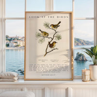 May include: A framed vertical wall art print featuring three small birds perched on a pine branch. The text reads LOOK AT THE BIRDS at the top and includes the full Matthew 6:26-27 scripture passage at the bottom in a clean, black serif font.