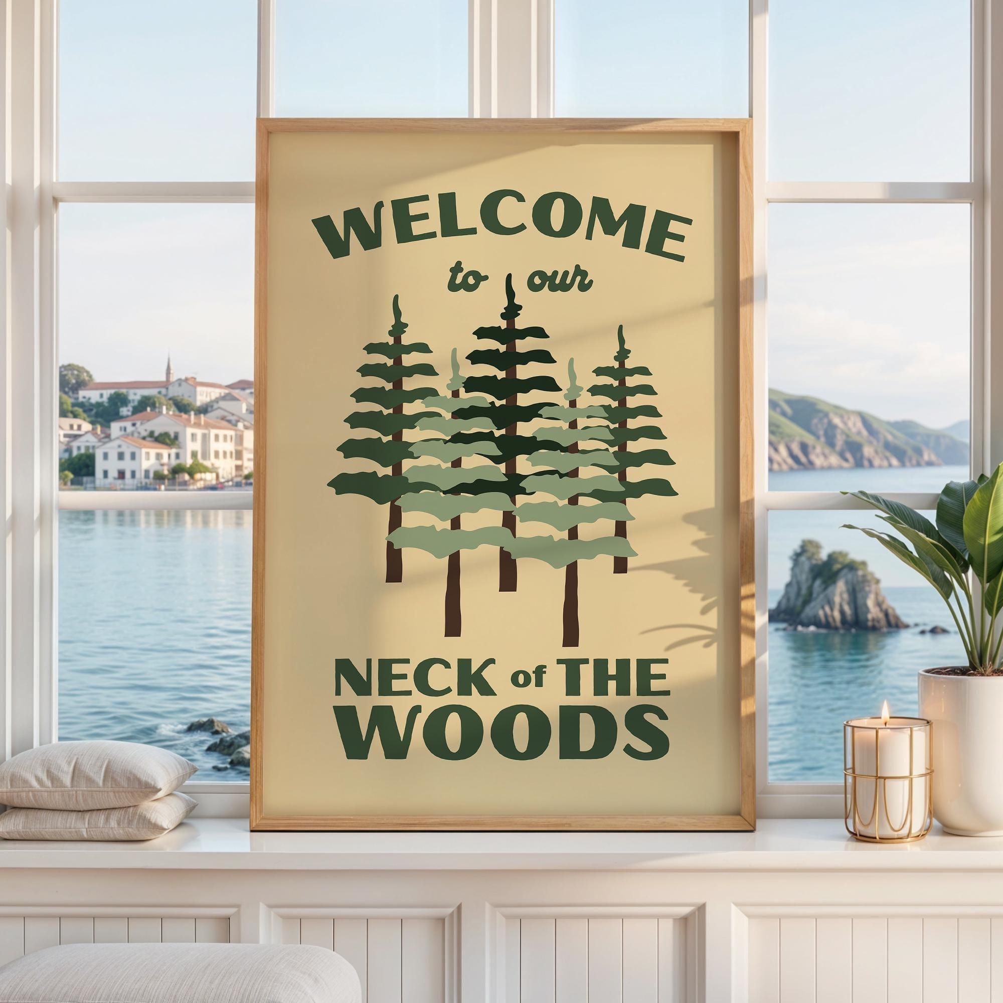 May include: A rectangular wall art print in a light wood frame featuring a cream background with dark green text that reads WELCOME to our NECK of THE WOODS. The design includes a central illustration of five stylized pine trees in green.
