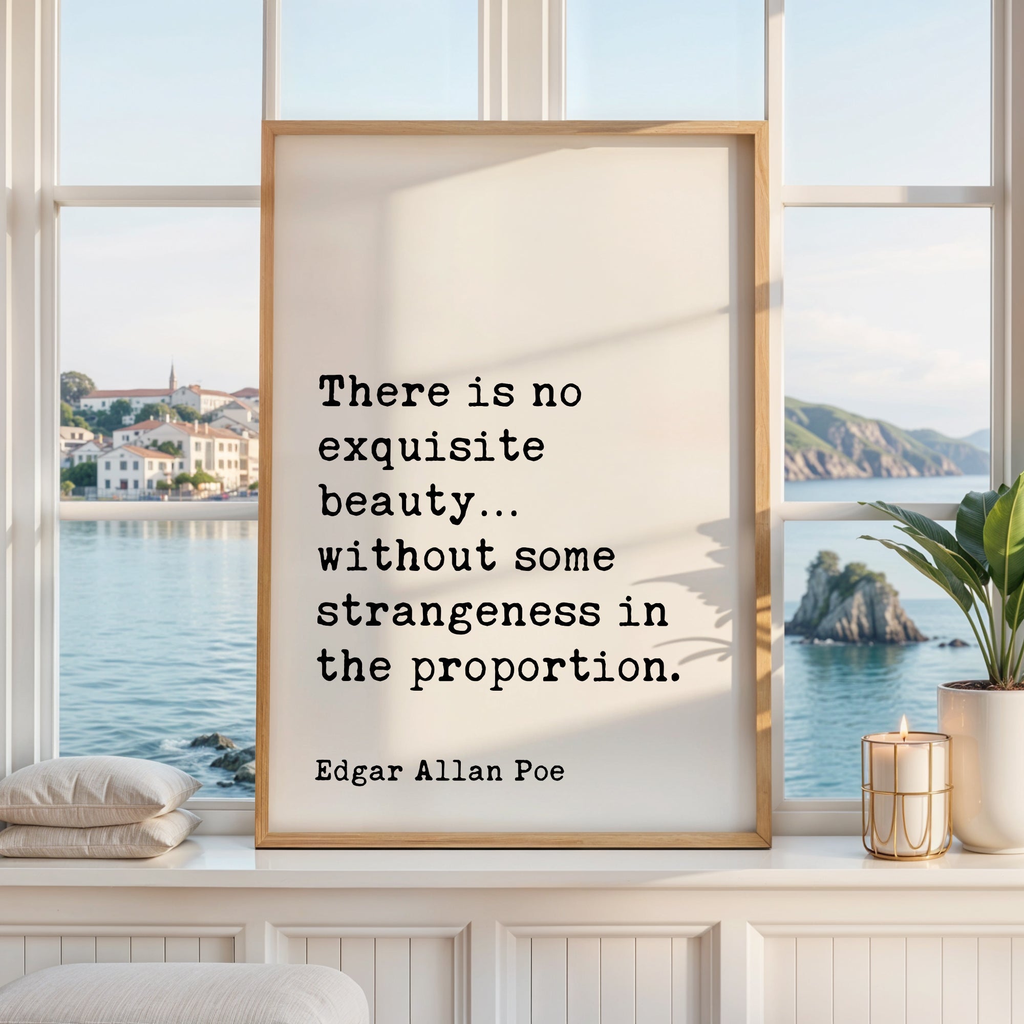 a framed quote by Edgar Allan Poe, which reads "There is no exquisite beauty... without some strangeness in the proportion." The quote is displayed in a white frame, and the background shows a scenic view of a body of water and a distant town.