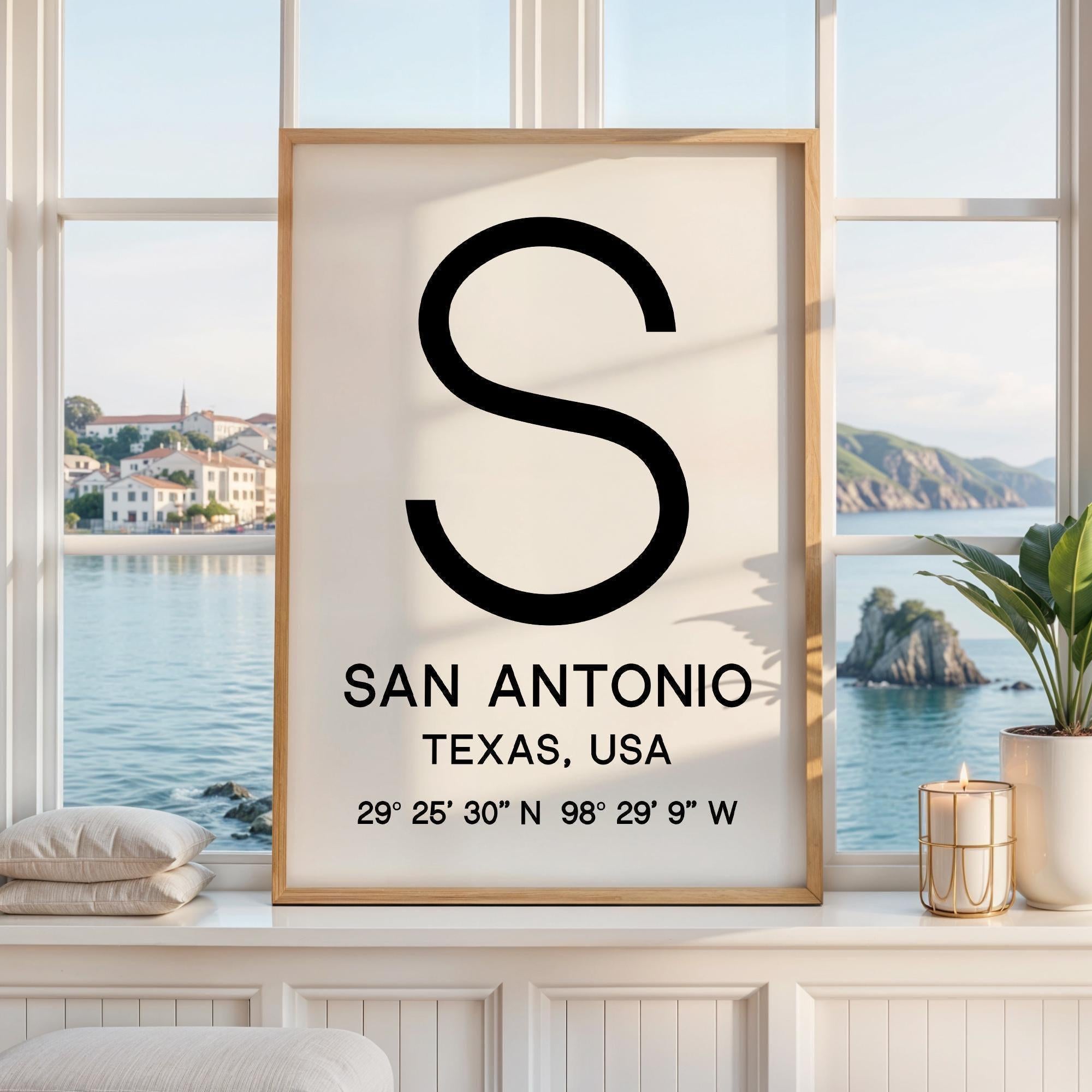 May include: A framed vertical wall art print featuring a large black letter S at the top, followed by the text SAN ANTONIO, TEXAS, USA, and the geographic coordinates 29° 25' 30" N 98° 29' 9" W printed in black on a white background.